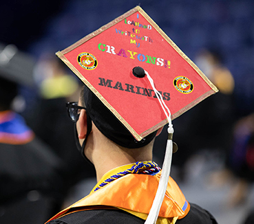 image of masters graduate with marine-related decorated cap